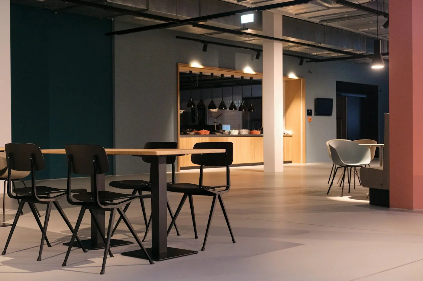 Metal-frame dining chairs and supported tables beside a restaurant service area