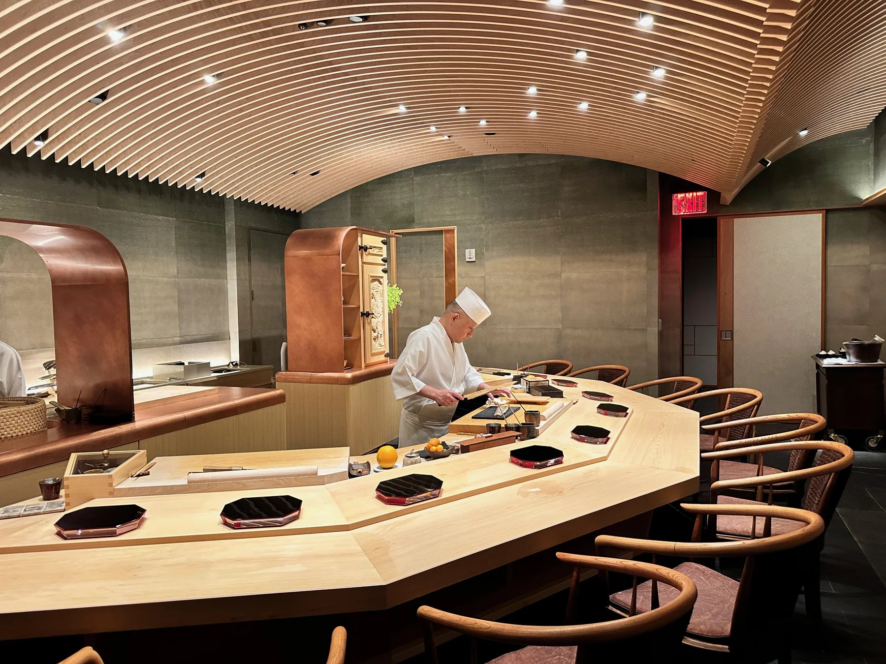 Chef working behind the wooden counter at Sushi Sho, New York