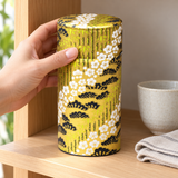 1920BG gold pine and blossom washi tea canister being retrieved from a tea shelf