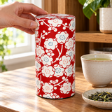 Red and white blossom tea canister being reached for at a tea station