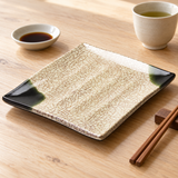 508-O rectangular Oribe-pattern plate with dark green corners beside tea, soy dish and chopsticks on a wood table