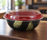 HD-1000 empty gold-brush bowl with clear lid at a pickup counter