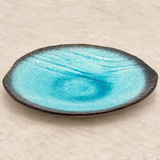 FDKN-1 turquoise glazed plate in a neutral tabletop setting