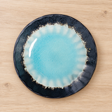 HS245-FB blue glazed ceramic plate on a wooden tabletop, overhead view