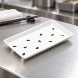 KM5924 white porcelain sushi case plate with eleven gourd-shaped openings on a restaurant preparation counter