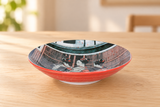 KN286-GE illustrated ceramic deep plate with red exterior on a light wood table