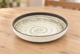 MS57-AS beige spiral-pattern ceramic plate on a light wood table