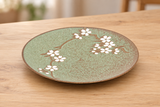 MT210-SG green and brown sakura ceramic plate on a light wood table
