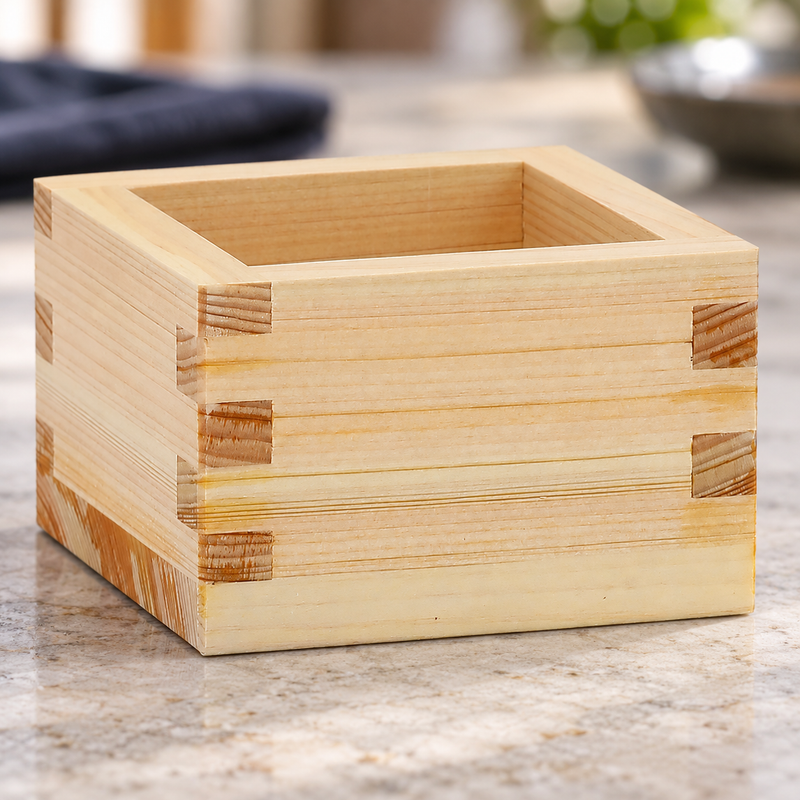 OMS-103 wooden masu cup on a pale tabletop, showing its grain and corner joints