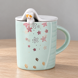 PC40-2 mint floral mug with cat and raised lid on a wooden table