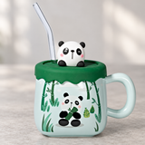 PC52-1 panda mug with green lid and clear straw on a café table