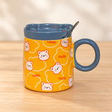 PC54-4 orange bear-print mug with blue-gray lid and spoon on a pale wood tabletop