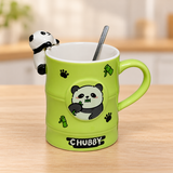 PC61-1 green CHUBBY panda mug with rim figure and spoon on a pale wood tabletop
