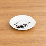 PT25-C white plum blossom round plate on a light wood table