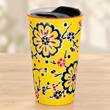 SM12-5315 yellow floral tumbler with black lid on a pale wood tabletop