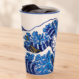 SM12-6599 blue wave tumbler with black lid on a pale wood tabletop