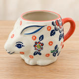 SMR-11 multicolor floral rabbit mug on a pale wood tabletop