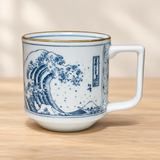 WA72-WV white and blue wave mug with gold-toned rim on a pale wood tabletop