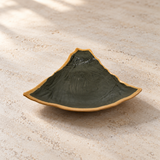 Dark triangular plate with ochre rim on a neutral stone tabletop, empty contextual view