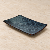 Ceramic serving dish on a neutral stone tabletop, same-view context