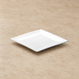 White plate on a neutral stone tabletop, same-view context
