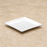 White plate on a neutral stone tabletop, same-view context