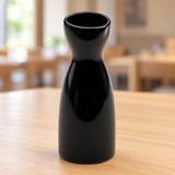 A1889-B black ceramic sake bottle in a table setting
