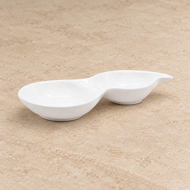 A19474 white porcelain two-well dish on a neutral stone tabletop
