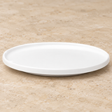 White plate on a neutral stone tabletop, same-view context