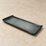 Ceramic serving dish on a neutral stone tabletop, same-view context