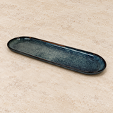 Ceramic serving dish on a neutral stone tabletop, same-view context