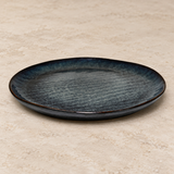 Ceramic serving dish on a neutral stone tabletop, same-view context
