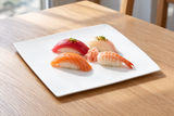 A2836 white flat square plate with nigiri sushi on a restaurant table.