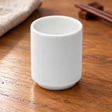A3912 plain white sake cup on a wooden restaurant table