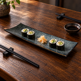 A6666-OB rectangular Obsidian platter with four small maki and ginger in a shared table setting