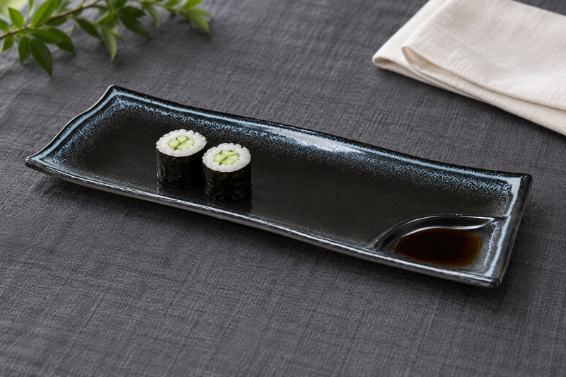 AS212-BK black ceramic divided plate with two cucumber maki and soy sauce in its corner well, serving suggestion
