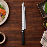 IKKAKU Bessaku 270 mm yanagiba in a dark kitchen preparation setting