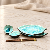 BH22-B blue leaf set with two stacked plates, two small dishes and two chopstick pairs, on a pale stone counter
