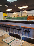 Black open-back plastic restaurant chair; restaurant setting, other furniture illustrative