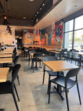 Black plastic restaurant chair; restaurant setting, other furniture illustrative