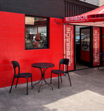 Black plastic restaurant chair; restaurant setting, other furniture illustrative