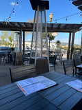 Black Stackable Indoor/Outdoor Chair with Black Aluminum Frame in a restaurant setting; other furniture is illustrative