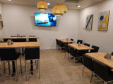 Black Upholstered Restaurant Chair with Stainless Steel Legs in a restaurant setting; other furniture is illustrative