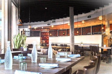 Brown Upholstered Restaurant Chair with Walnut-Finish Metal Frame in a restaurant setting; other furniture is illustrative