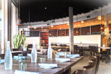 Brown Upholstered Restaurant Chair with Walnut-Finish Metal Frame in a restaurant setting; other furniture is illustrative