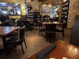Brown Upholstered Restaurant Chair with Walnut-Finish Metal Frame in a restaurant setting; other furniture is illustrative