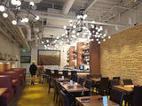 Brown Upholstered Restaurant Chair with Walnut-Finish Metal Frame in a restaurant setting; other furniture is illustrative