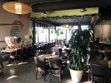 Brown Upholstered Restaurant Chair with Walnut-Finish Metal Frame in a restaurant setting; other furniture is illustrative