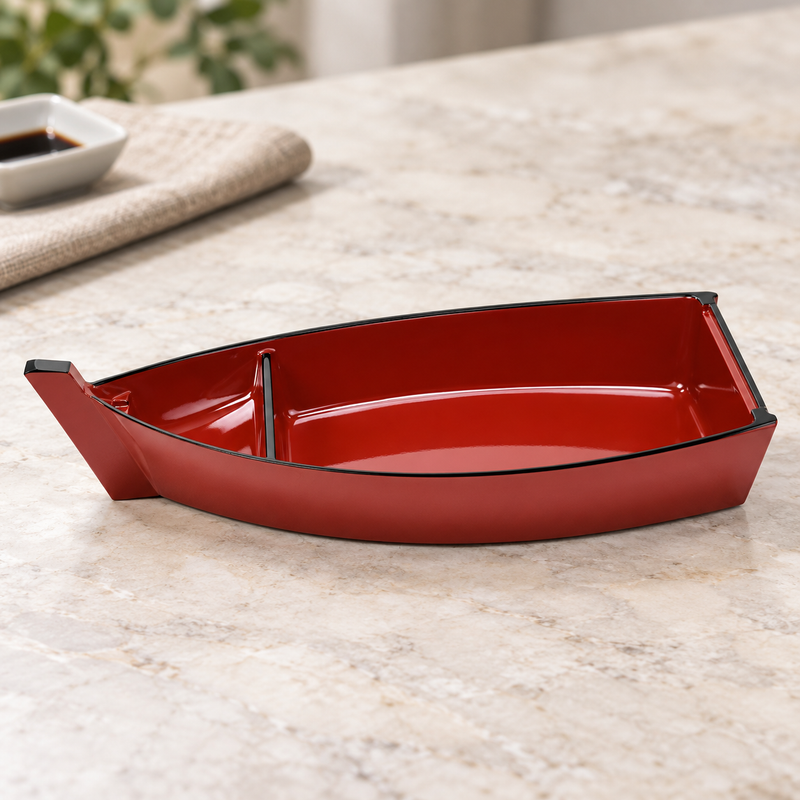 Empty red C100-R boat-shaped plate on a light stone tabletop