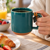 C010 teal ceramic mug in a hand-held breakfast setting; contextual accessories not included.